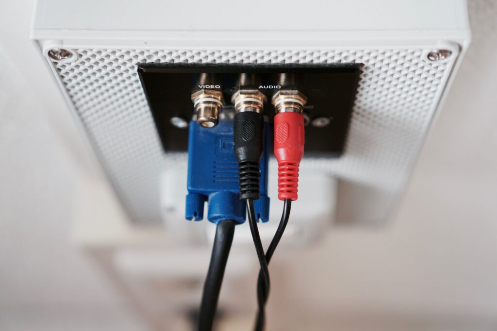 Detailed view of audio and video input cables connected to a wall socket.