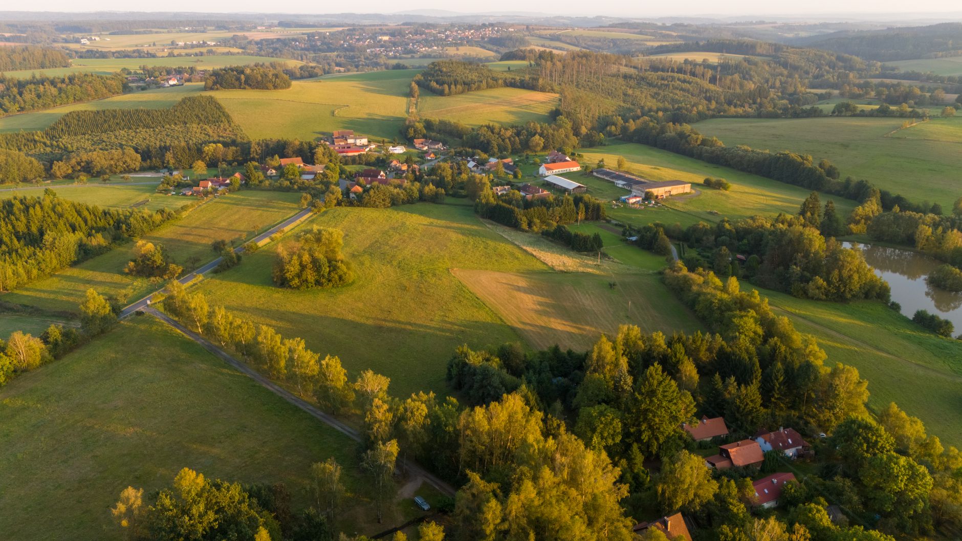Idyllic aerial view of lush countryside fields and forest in Bohemia.