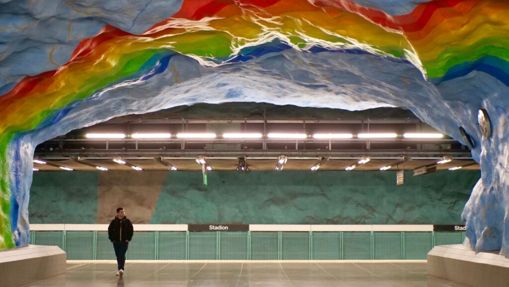 A vibrant view of the Stadion metro station with rainbow art in Stockholm.