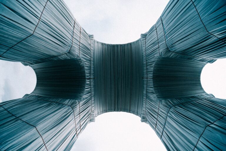 A captivating view of the wrapped Arc de Triomphe in Paris showcasing its unique fabric covering from a low angle.