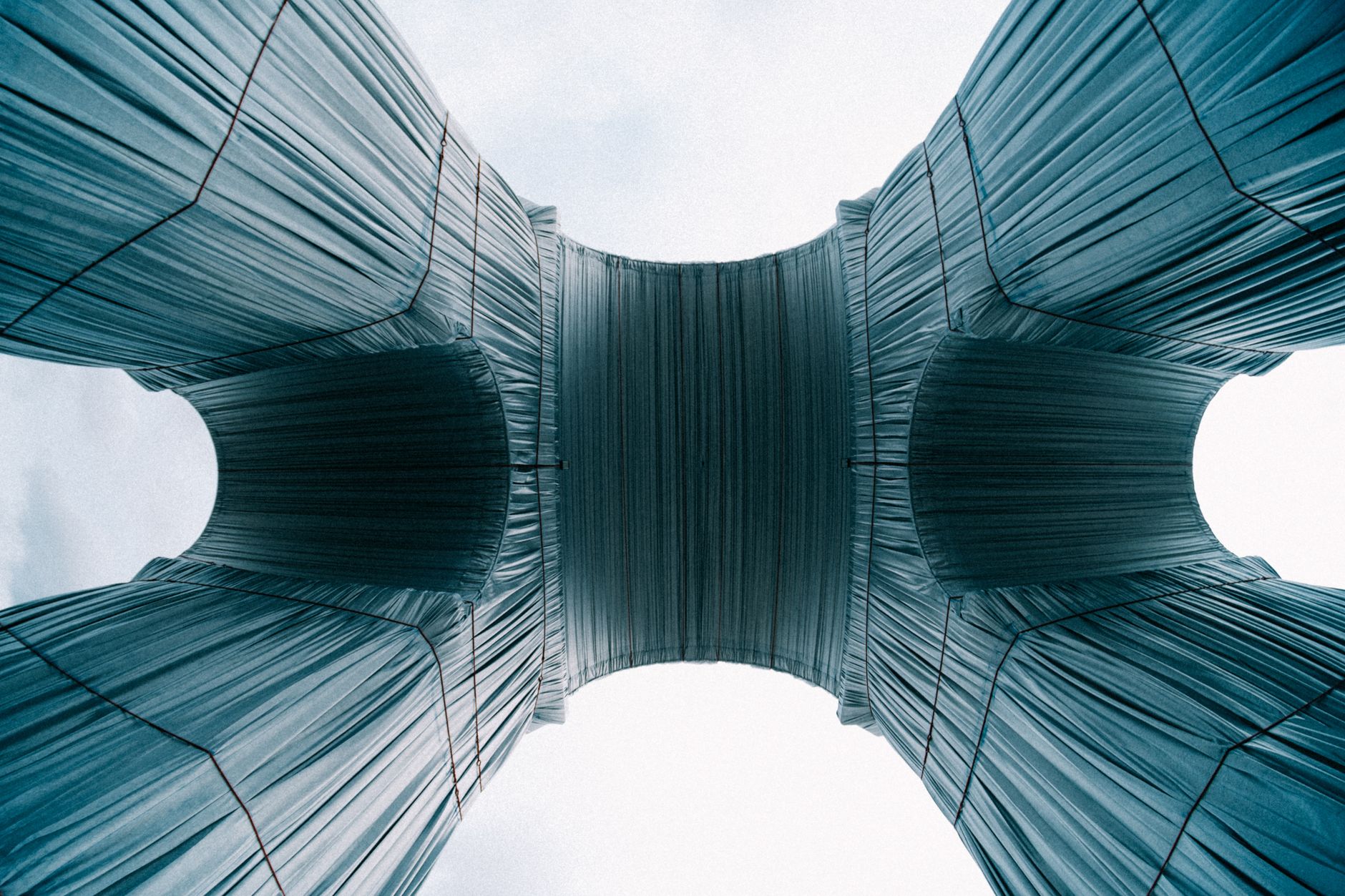 A captivating view of the wrapped Arc de Triomphe in Paris showcasing its unique fabric covering from a low angle.