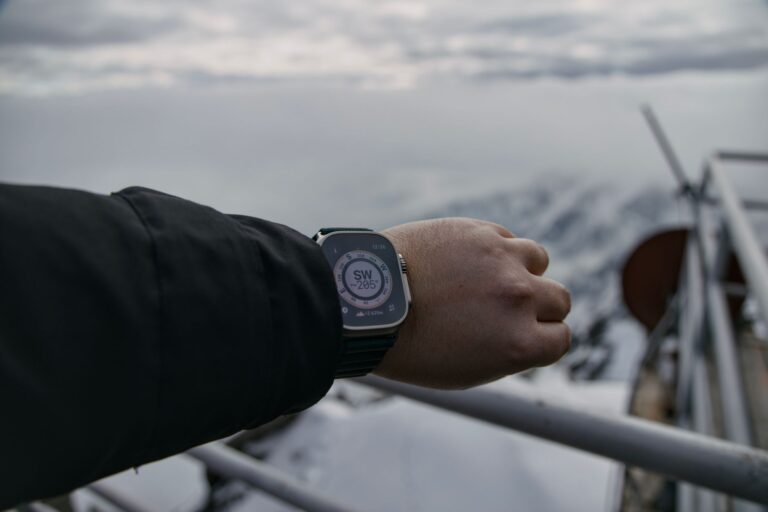 Hiker using a smartwatch compass in snowy Vysoké Tatry, Slovakia.
