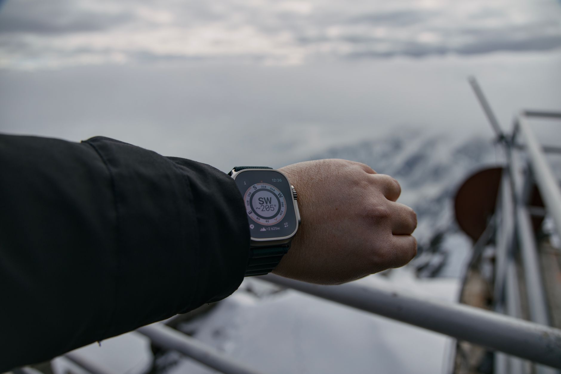Hiker using a smartwatch compass in snowy Vysoké Tatry, Slovakia.