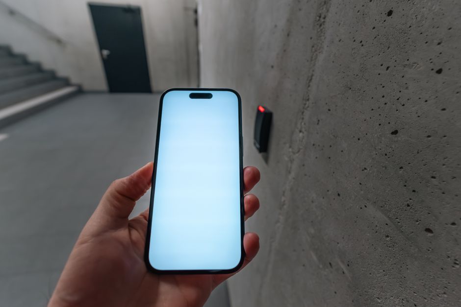 En mobiltelefon brukes mot en adgangsleser som illustrasjon av digital identitet og autorisasjon.