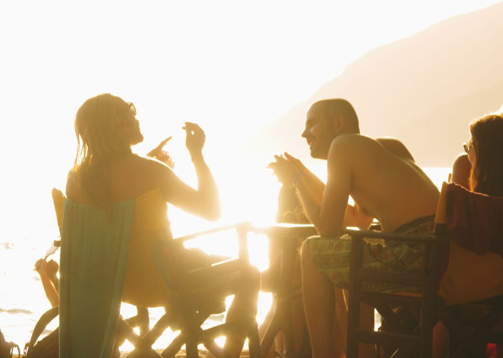 People enjoying a vibrant sunset beach gathering in Naxos, Greece, creating a warm and lively atmosphere.