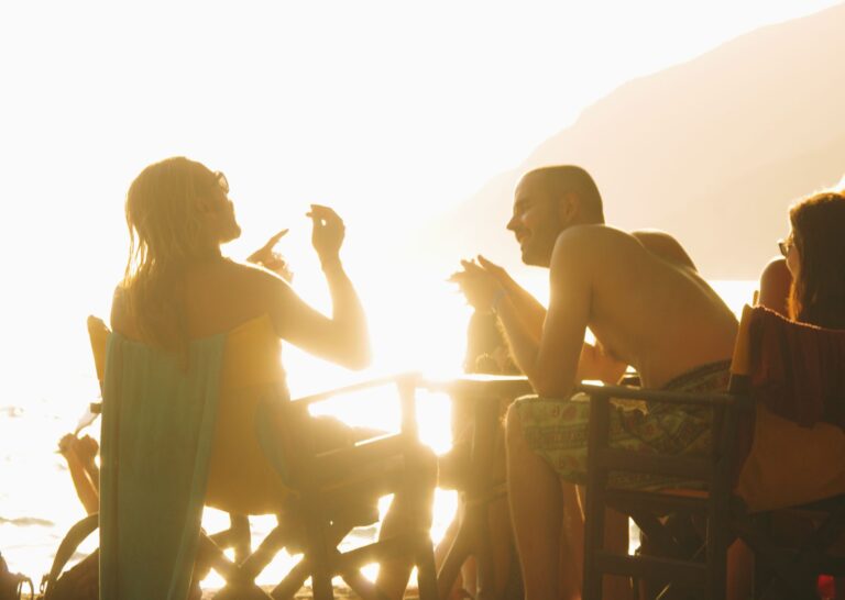 People enjoying a vibrant sunset beach gathering in Naxos, Greece, creating a warm and lively atmosphere.