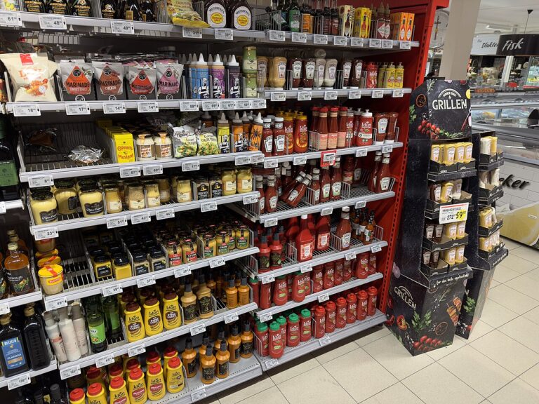 Groceries/food items/consumer goods for sale displayed on shelves/store shelves with price tags, in a grocery store/general store/supermarket in Norway in…